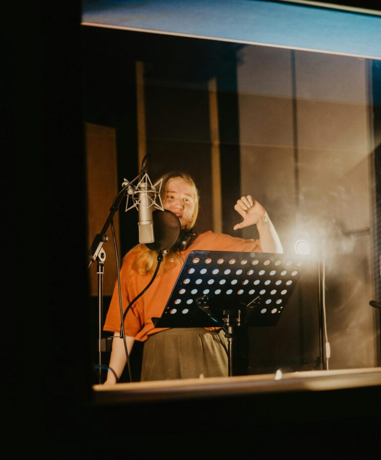 Cantante con microfono – imitare un’altra voce può causare affaticamento vocale